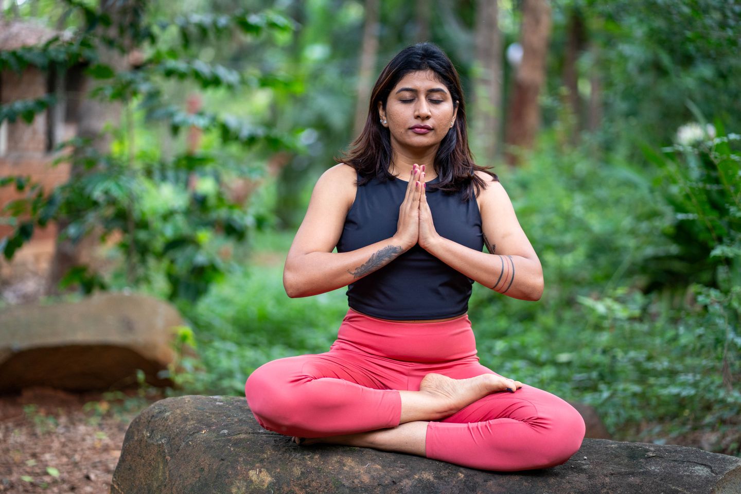 A woman practices meditation outdoors, demonstrating mindfulness and relaxation.